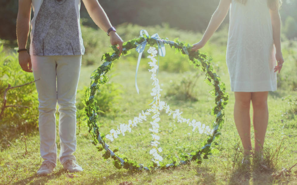 couple with a peace sign standing in a field